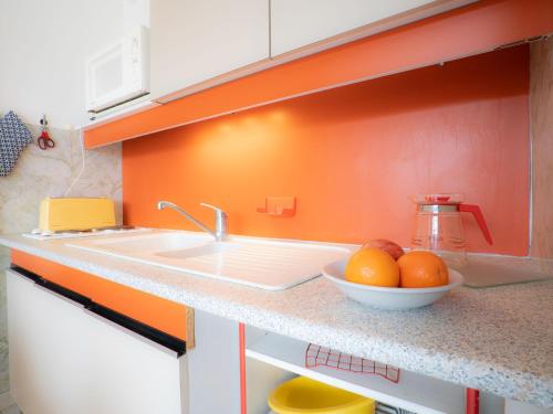 une cuisine avec un évier et un bol d'oranges dans l'établissement Studio Escale Port-1 by Interhome, au Grau-du-Roi