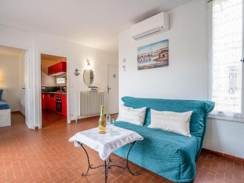 un salon avec un canapé bleu et une table dans l'établissement Holiday Home Grau Village-1 by Interhome, au Grau-du-Roi