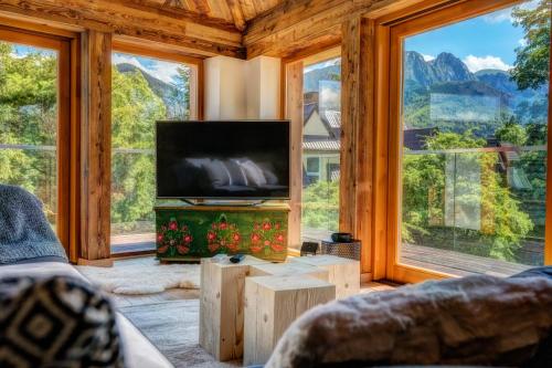 a living room with a tv and large windows at Aparthotel Gievont Boutique in Zakopane