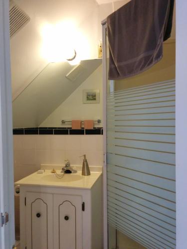 a white bathroom with a sink and a staircase at Fairmont House Bed & Breakfast in Mahone Bay