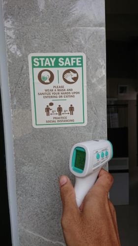 a person holding a remote control in front of a sign at EDUTAMA Homestay Syariah in Kediri