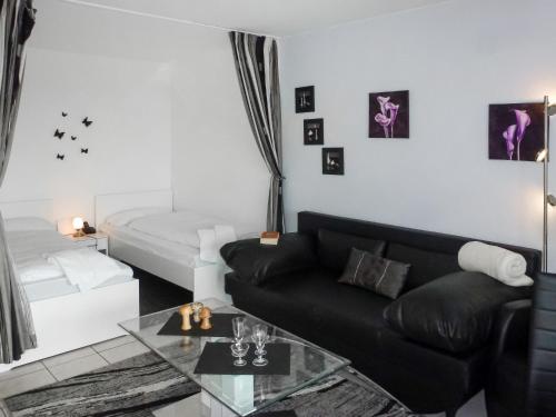 a living room with a black couch and a table at Apartment B 97 by Interhome in Dittishausen