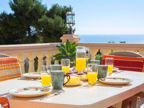 una mesa con platos de comida y vasos de zumo de naranja en Holiday Home Meluca by Interhome, en Calpe