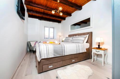 een slaapkamer met een groot bed en een houten plafond bij Holiday Home - Casa di Antonio in Kanfanar