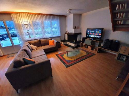 a living room with a couch and a flat screen tv at Apartment Casa Milu by Interhome in Engelberg