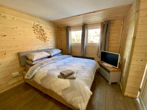 um pequeno quarto com uma cama e uma televisão em Southernwood - Wantage Road Lodge em Didcot