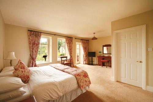 a bedroom with a bed and a window and a desk at Best Western Limpley Stoke Hotel in Bath