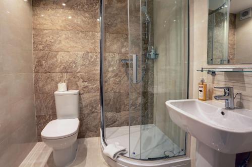 ein Bad mit einer Dusche, einem WC und einem Waschbecken in der Unterkunft Best Western Homestead Court Hotel in Welwyn Garden City