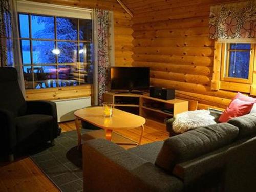 salon z kanapą i stołem w obiekcie Holiday Home Metsä-pihlaja by Interhome w mieście Kinnula