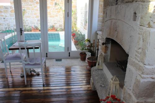 a living room with a stone fireplace and a table and chairs at Eski Tas Hotel in Cesme