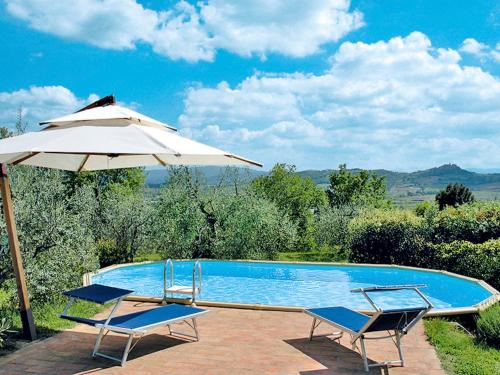 basen z 2 krzesłami i parasolem w obiekcie Holiday Home Il Fienile by Interhome w mieście Lucciana