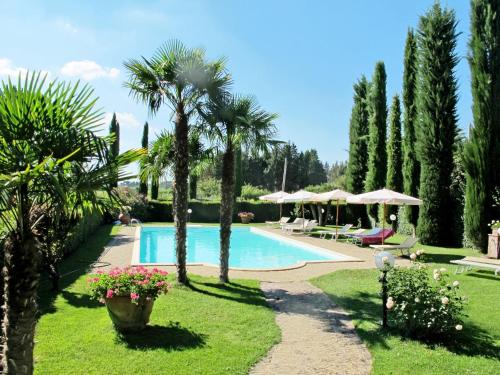 una piscina in un giardino con palme di Holiday Home Giuggiolo - Giuggiolo 3 by Interhome a Poggibonsi