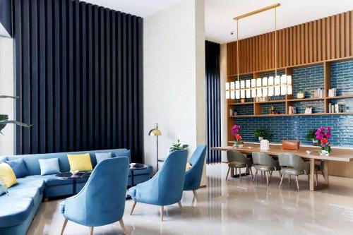 - un salon avec un canapé bleu, une table et des chaises dans l'établissement Quality Hotel Zhangye, à Zhangye
