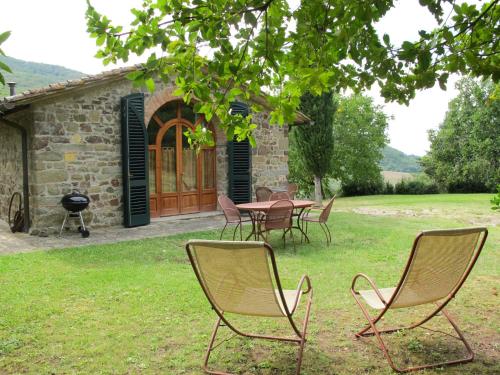 einer Gruppe von Stühlen und einem Tisch vor einem Gebäude in der Unterkunft Holiday Home Il Poderino by Interhome in Chiocchio