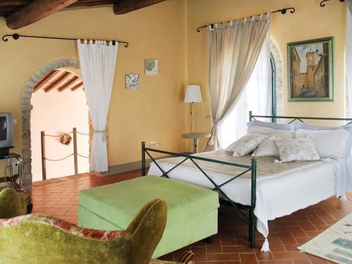 a bedroom with a bed and a chair at Holiday Home Santa Enerichetta by Interhome in Pomarance