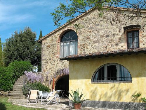 una casa in pietra con sedie e patio di Holiday Home Podere San Raffaele - Cinzia by Interhome a Poggibonsi