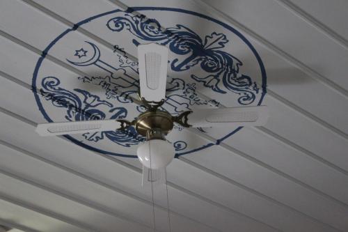 a ceiling fan with a blue and white design on a ceiling at Eski Tas Hotel in Cesme