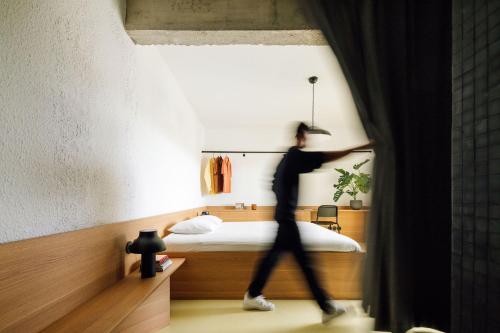 Un uomo che cammina in una camera con un letto di Boavista Apartment by Olala Homes a Cascais