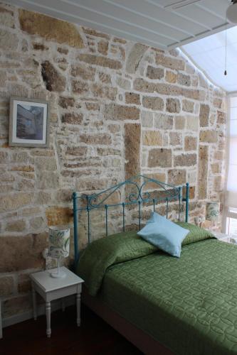 a bedroom with a bed in a brick wall at Eski Tas Hotel in Cesme