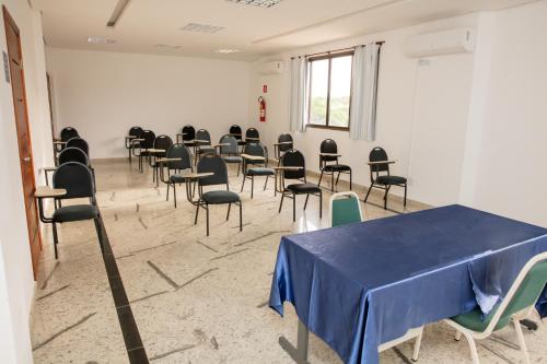 a room with a blue table and chairs in it at Fênix Hotel Varginha in Varginha