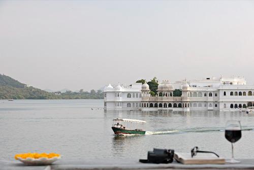 a boat in the water in front of a large building at Amet Haveli - A Heritage Hotel Udaipur in Udaipur