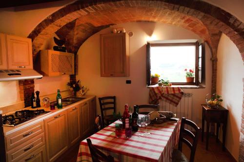 cocina con mesa y mantel rojo y blanco en Antico Borgo De' Frati, en San Gimignano