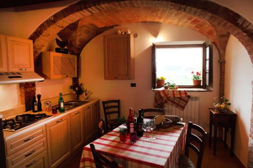 サン・ジミニャーノにあるAntico Borgo De' Fratiのキッチン(テーブル、赤と白のテーブルクロス付)