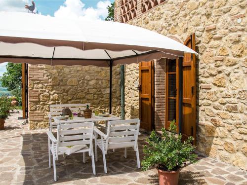 un tavolo e sedie sotto un ombrellone su un patio di Holiday Home Casolare Ser Chelino by Interhome a Volterra