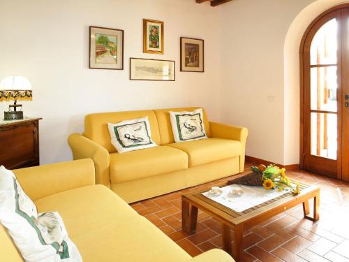 Sala de estar con sofá amarillo y mesa de centro en Holiday Home Casolare Ser Chelino by Interhome, en Volterra