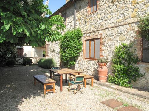 a picnic table and chairs in front of a building at Apartment Cellole - Cellole 2 - CTC151 by Interhome in Castellina in Chianti