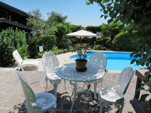 a patio with a table and chairs next to a pool at Apartment Villa Margherita-3 by Interhome in Anduins