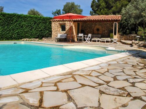 - une piscine avec un parasol rouge à côté d'une maison dans l'établissement Villa La Chênaie by Interhome, à Saumane-de-Vaucluse