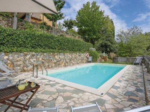 a swimming pool with a stone wall next to anergynergy at Holiday Home Maestraccio by Interhome in Buti