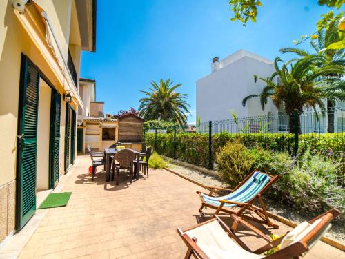 a patio with chairs and tables and a building at Holiday Home Les Savines by Interhome in Alcudia