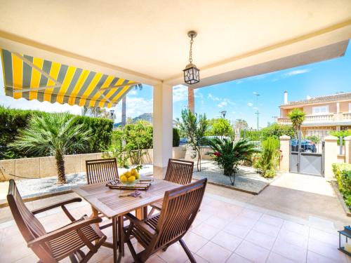 a patio with a wooden table and chairs with a view at Holiday Home Les Savines by Interhome in Alcudia