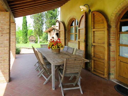 una mesa de madera y sillas en un patio en Holiday Home La Voce del Silenzio by Interhome, en Volterra