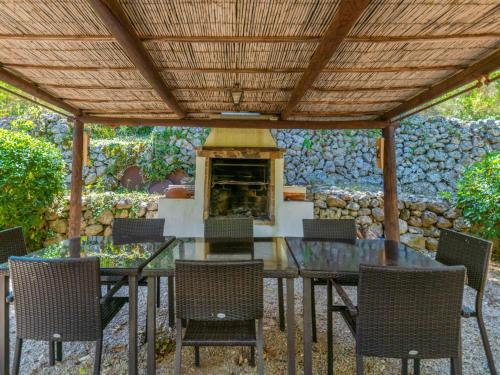 eine Terrasse mit einem Tisch, Stühlen und einem Kamin in der Unterkunft Holiday Home Varitx Paradise by Interhome in Pollença