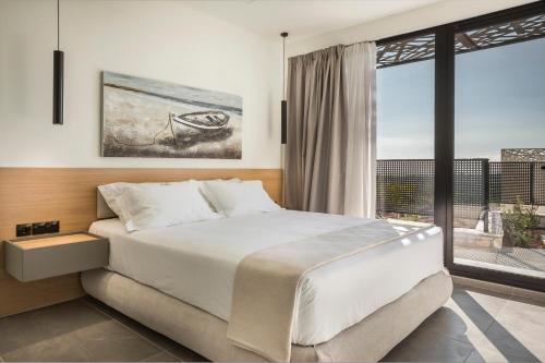 a bedroom with a large bed and a large window at Erolidae Villas in Atsoupádhes