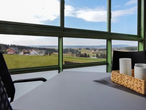 a table with a view of a field through a window at Apartment B 110 in Dittishausen