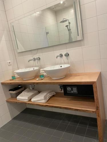 a bathroom with two white sinks and a mirror at Slot Oostende in Goes