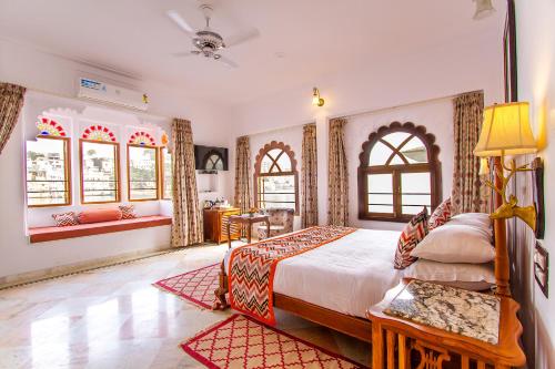 a bedroom with a bed and two windows at Amet Haveli - A Heritage Hotel Udaipur in Udaipur
