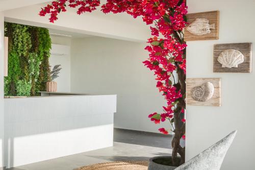 a floral arch in a room with red flowers at Erolidae Villas in Atsoupádhes