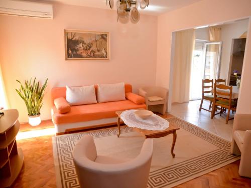 sala de estar con sofá naranja y mesa en Apartments and Rooms Antonio, en Zadar