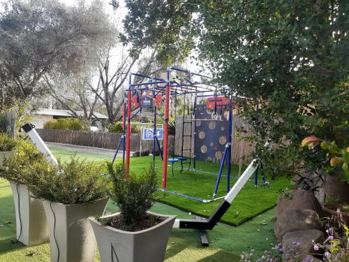 a playground in a yard with potted plants at Love & Lemons in Yesod Hamaala