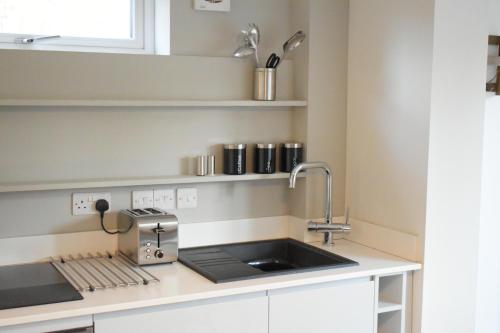 a kitchen with a sink and a mixer on a counter at University Walk in Loughborough