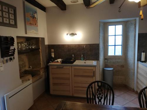 uma cozinha com um lavatório, uma mesa e uma janela em Great cottage near Bergerac and wineries France em Saint-Méard-de-Gurçon