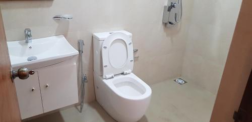 a bathroom with a white toilet and a sink at Hotel ColdWorld in Nuwara Eliya