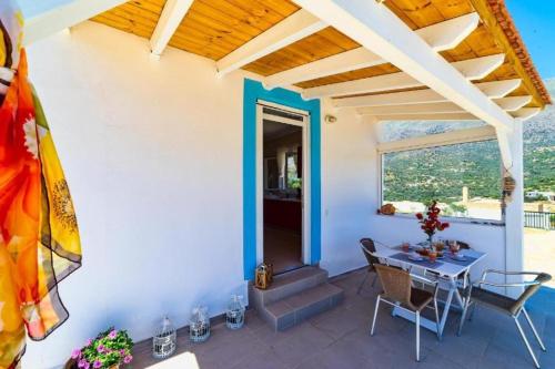 a patio with a table and chairs and a window at Emmanuela House with garden & sea view - Triopetra in Triopetra