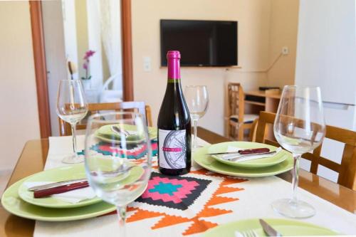 a bottle of wine sitting on a table with glasses at Emmanuela House with garden & sea view - Triopetra in Triopetra