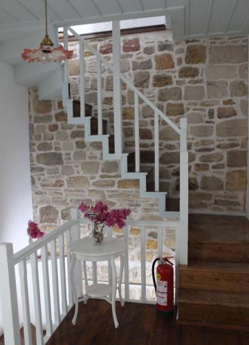 a white staircase with a vase of flowers on a table at Eski Tas Hotel in Cesme